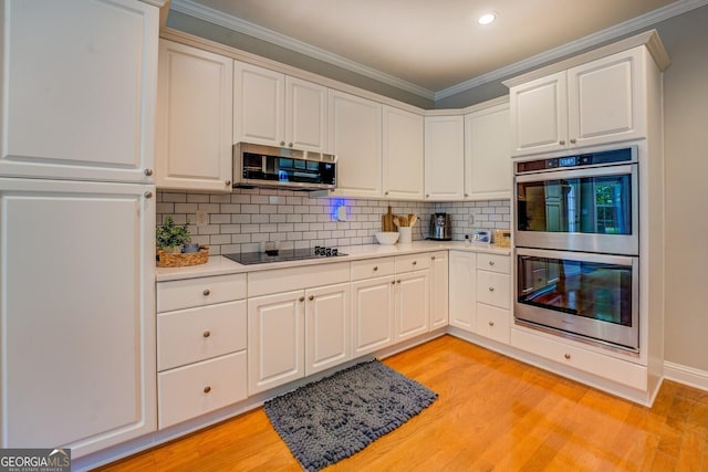 kitchen featuring appliances with stainless steel finishes, light countertops, light wood-type flooring, ornamental molding, and recessed lighting