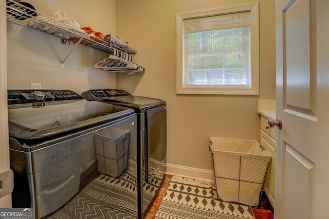 clothes washing area with independent washer and dryer, baseboards, and tile patterned flooring