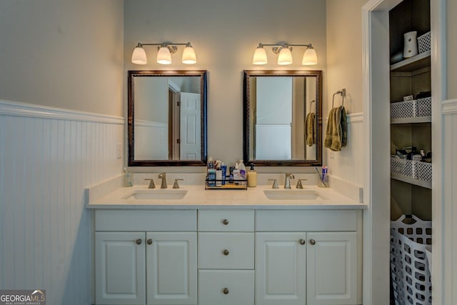 bathroom featuring double vanity and wainscoting