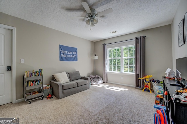 rec room featuring carpet, ceiling fan, a textured ceiling, and baseboards