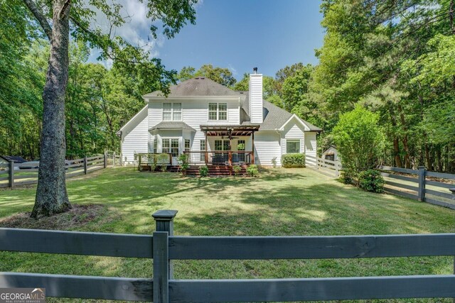 rear view of house with a wooden deck and a chimney