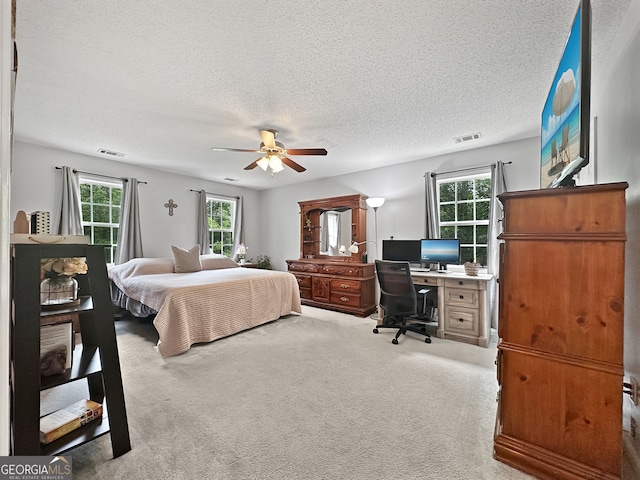 bedroom with carpet flooring, a textured ceiling, and visible vents