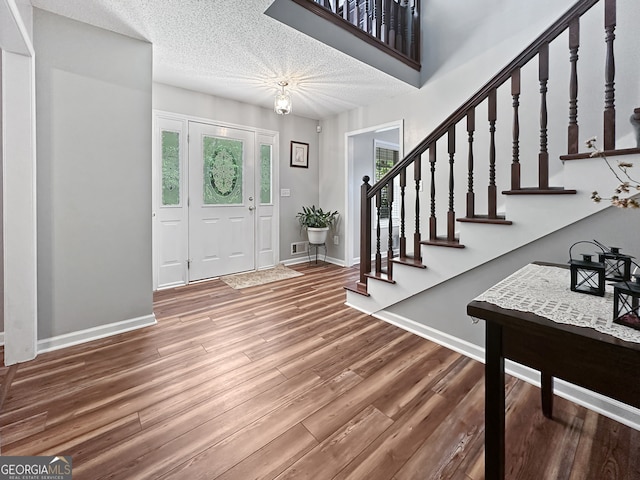 entrance foyer with stairs, baseboards, and wood finished floors