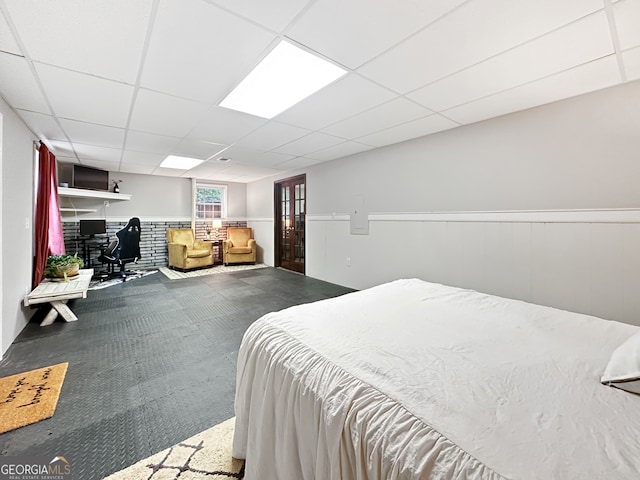 bedroom featuring wainscoting and a paneled ceiling