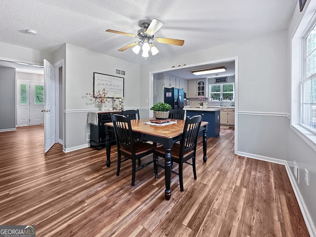 dining area featuring baseboards, a ceiling fan, and wood finished floors