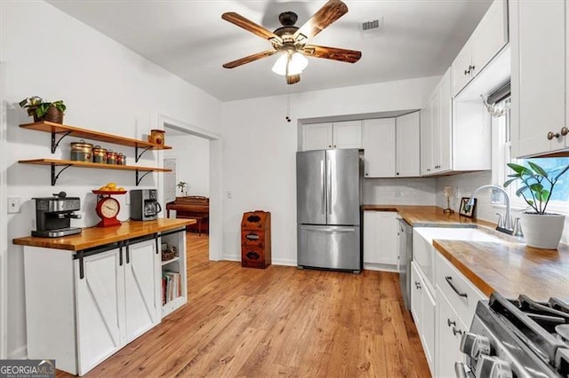 143 Navajo Trl, Rydal, GA 30171 - kitchen with appliances with stainless steel finishes, open shelves, ceiling fan, a sink, and butcher block counters