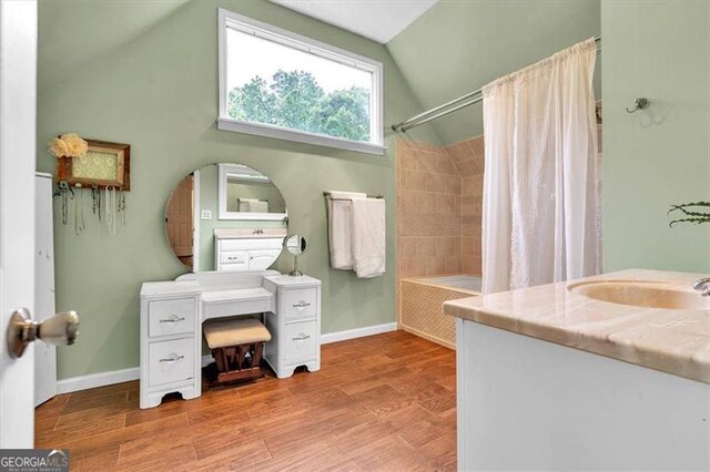 143 Navajo Trl, Rydal, GA 30171 - bathroom with lofted ceiling, wood finished floors, baseboards, shower / bathtub combination with curtain, and vanity