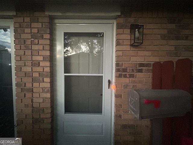 property entrance featuring brick siding