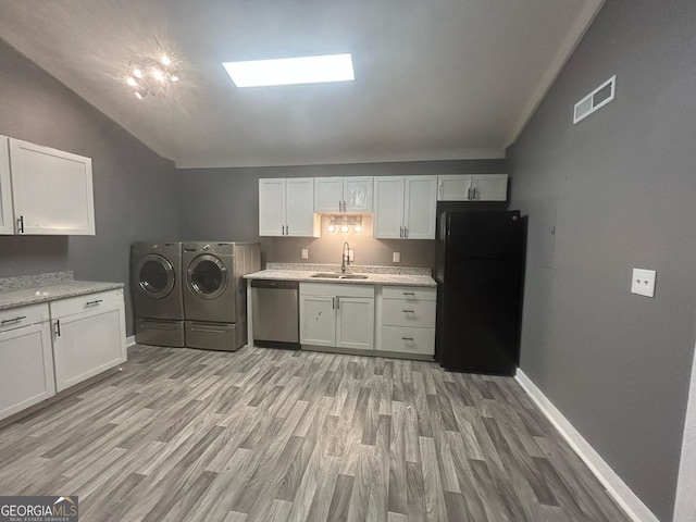 washroom with visible vents, laundry area, washing machine and dryer, baseboards, and a sink