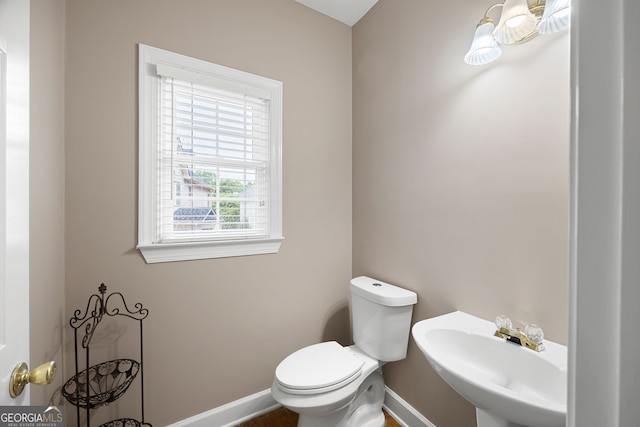 bathroom with a sink, baseboards, and toilet