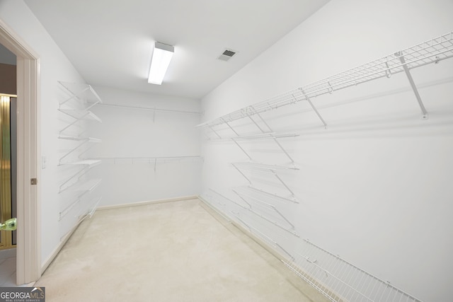 spacious closet featuring light colored carpet and visible vents