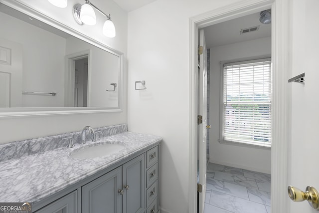 full bath with baseboards, visible vents, marble finish floor, and vanity