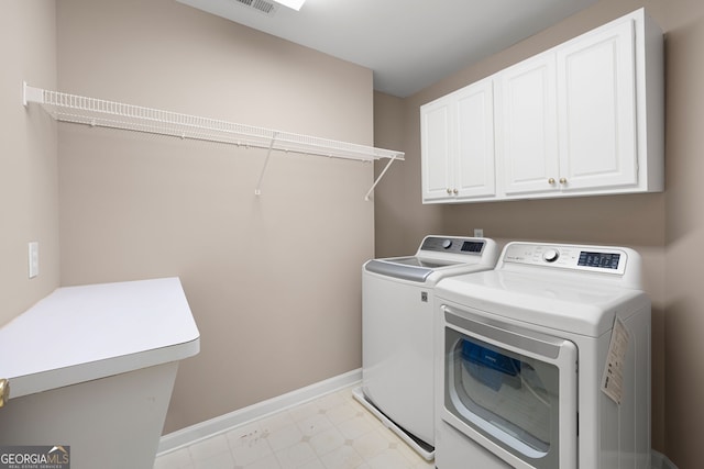 laundry area featuring cabinet space, separate washer and dryer, and baseboards