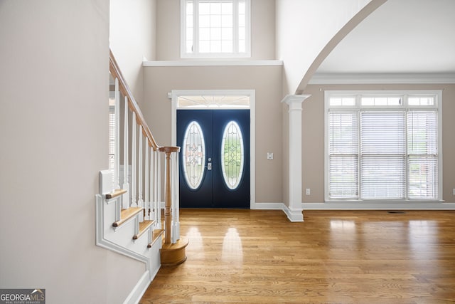 entrance foyer with arched walkways, a wealth of natural light, and stairway