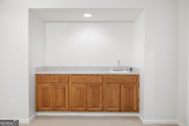bar featuring indoor wet bar, recessed lighting, baseboards, and a sink