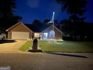 single story home with concrete driveway, an attached garage, and a yard