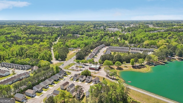birds eye view of property with a water view and a view of trees