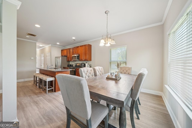 dining space featuring ornamental molding, a notable chandelier, light wood-style flooring, and visible vents