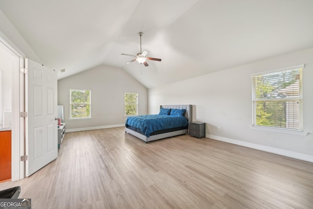 bedroom with light wood-style floors, baseboards, ceiling fan, and lofted ceiling