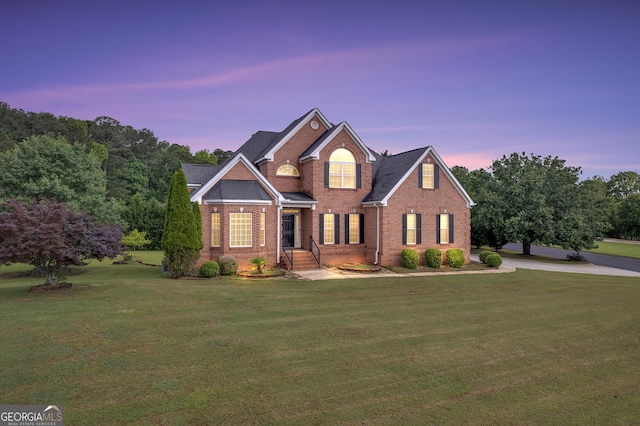 view of front of home with a front lawn and brick siding