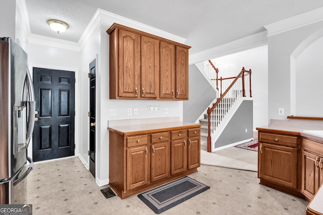 kitchen featuring ornamental molding, stainless steel fridge, arched walkways, and brown cabinets