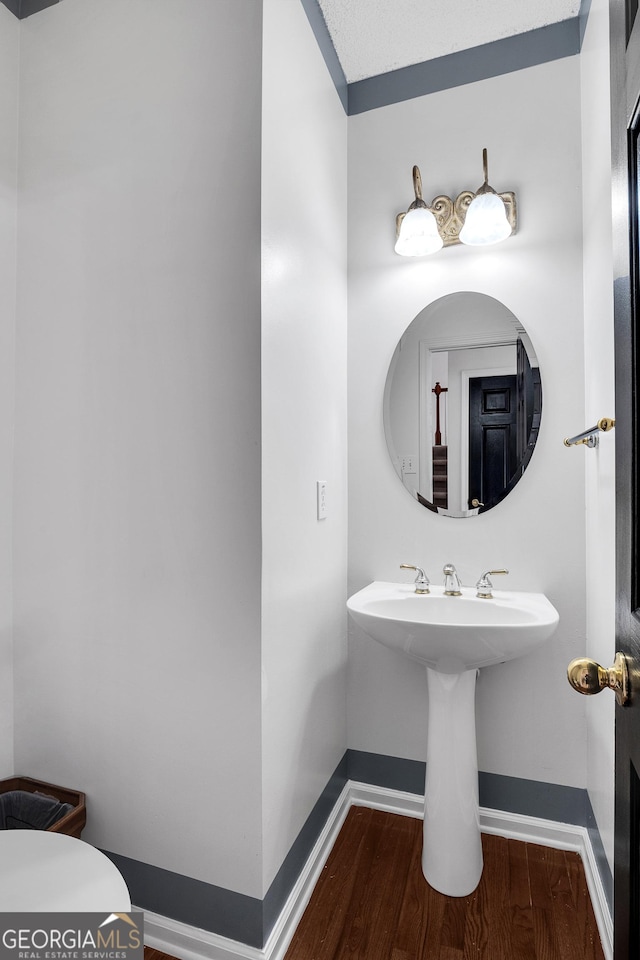 bathroom featuring wood finished floors, baseboards, and toilet