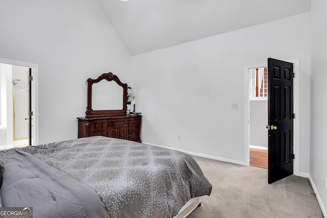 bedroom with light colored carpet, lofted ceiling, and baseboards
