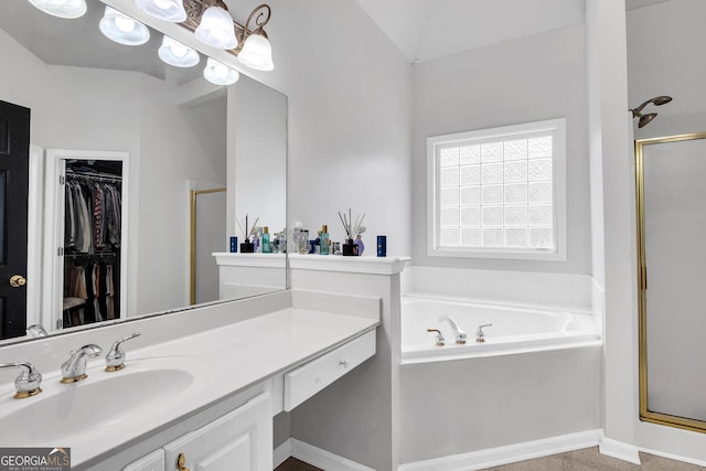 bathroom featuring a stall shower, vanity, a walk in closet, and a bath