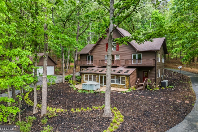339 Ben Loudermilk Rd, Mount Airy, GA 30563 - view of front of home featuring a balcony, an outbuilding, a hot tub, a shingled roof, and central AC unit