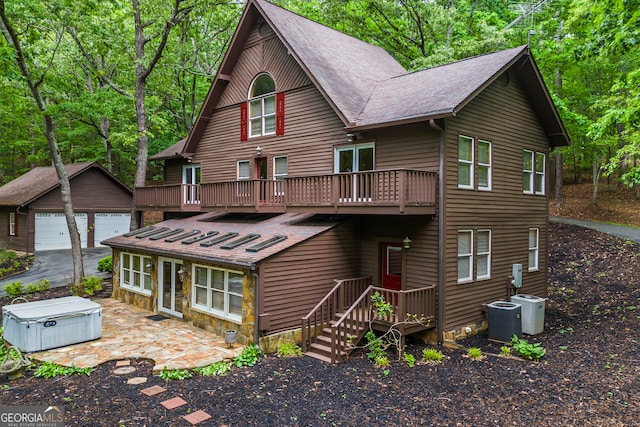 339 Ben Loudermilk Rd, Mount Airy, GA 30563 - back of house with a hot tub, a detached garage, a balcony, an outdoor structure, and a shingled roof