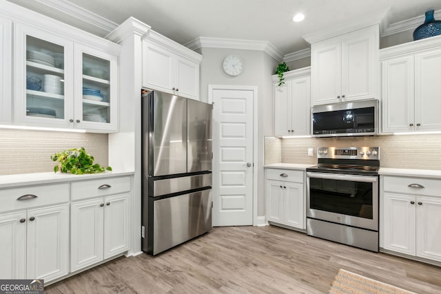 107 Amanda Trce, Kingsland, GA 31548 - kitchen featuring stainless steel appliances, light countertops, white cabinetry, ornamental molding, and light wood-style floors