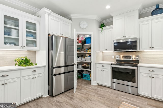 107 Amanda Trce, Kingsland, GA 31548 - kitchen featuring stainless steel appliances, light countertops, white cabinetry, ornamental molding, and decorative backsplash
