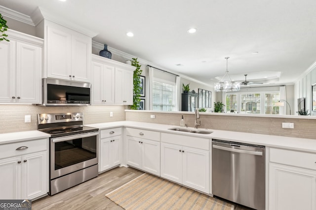 107 Amanda Trce, Kingsland, GA 31548 - kitchen with appliances with stainless steel finishes, a sink, crown molding, decorative backsplash, and light wood-style flooring