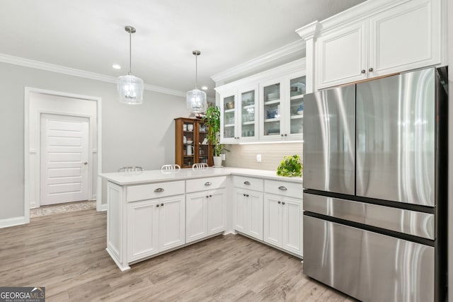 107 Amanda Trce, Kingsland, GA 31548 - kitchen featuring freestanding refrigerator, a peninsula, light countertops, ornamental molding, and white cabinets