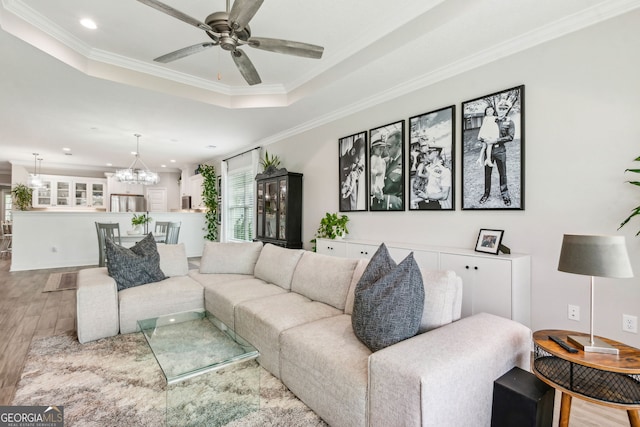 107 Amanda Trce, Kingsland, GA 31548 - living area featuring wood finished floors, ornamental molding, a raised ceiling, a chandelier, and a ceiling fan