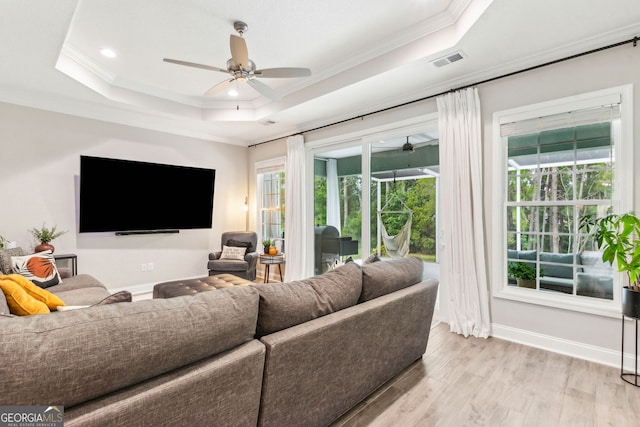 107 Amanda Trce, Kingsland, GA 31548 - living room featuring ceiling fan, a raised ceiling, light wood-type flooring, crown molding, and healthy amount of natural light
