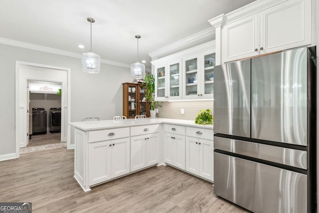 107 Amanda Trce, Kingsland, GA 31548 - kitchen with freestanding refrigerator, washing machine and clothes dryer, a peninsula, light countertops, and ornamental molding