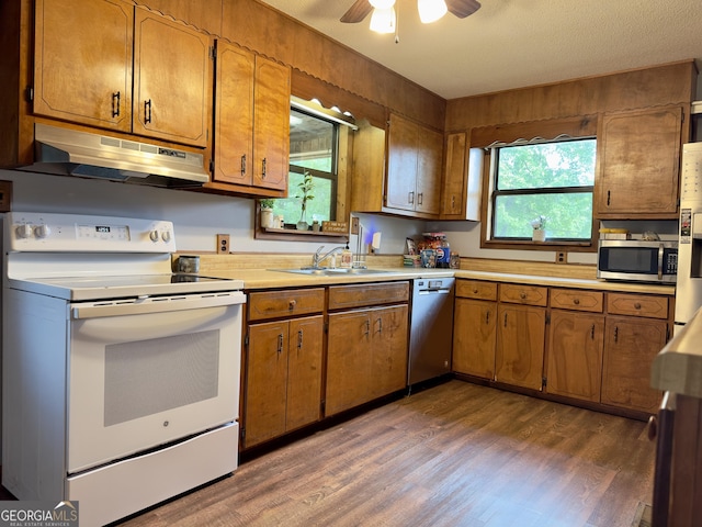1685 Ridgeway Rd, Lafayette, GA 30728 - kitchen with stainless steel appliances, under cabinet range hood, brown cabinetry, and wood finished floors