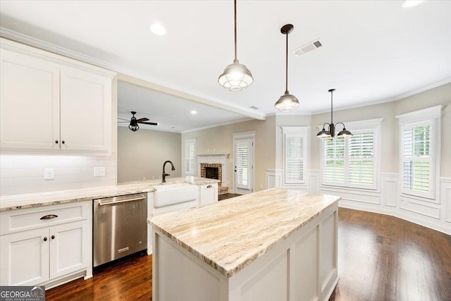 135 Broadleaf Dr, Macon, GA 31210 - kitchen featuring stainless steel dishwasher, decorative backsplash, dark wood-style flooring, white cabinetry, and a sink