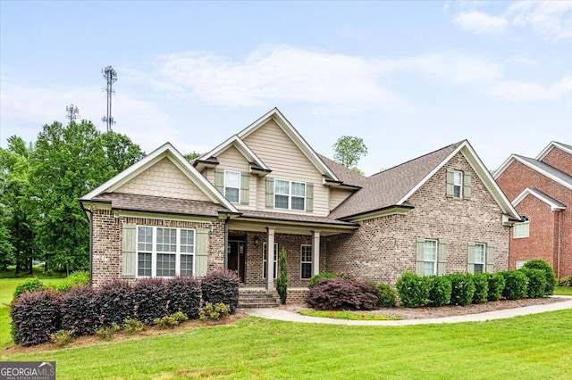 135 Broadleaf Dr, Macon, GA 31210 - craftsman-style home with a shingled roof, a porch, a front lawn, and brick siding