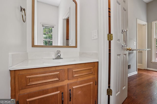 bathroom featuring wood finished floors, vanity, and baseboards