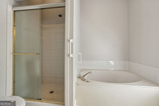 full bathroom with a shower stall, a garden tub, and toilet