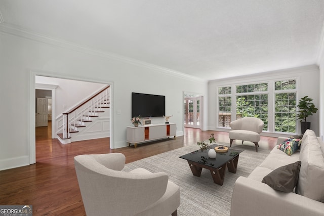 living room with ornamental molding, wood finished floors, stairs, and baseboards