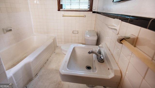full bath with a sink, tile walls, a washtub, and toilet