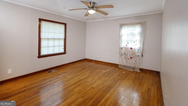 spare room featuring visible vents, light wood finished floors, ceiling fan, and a wealth of natural light