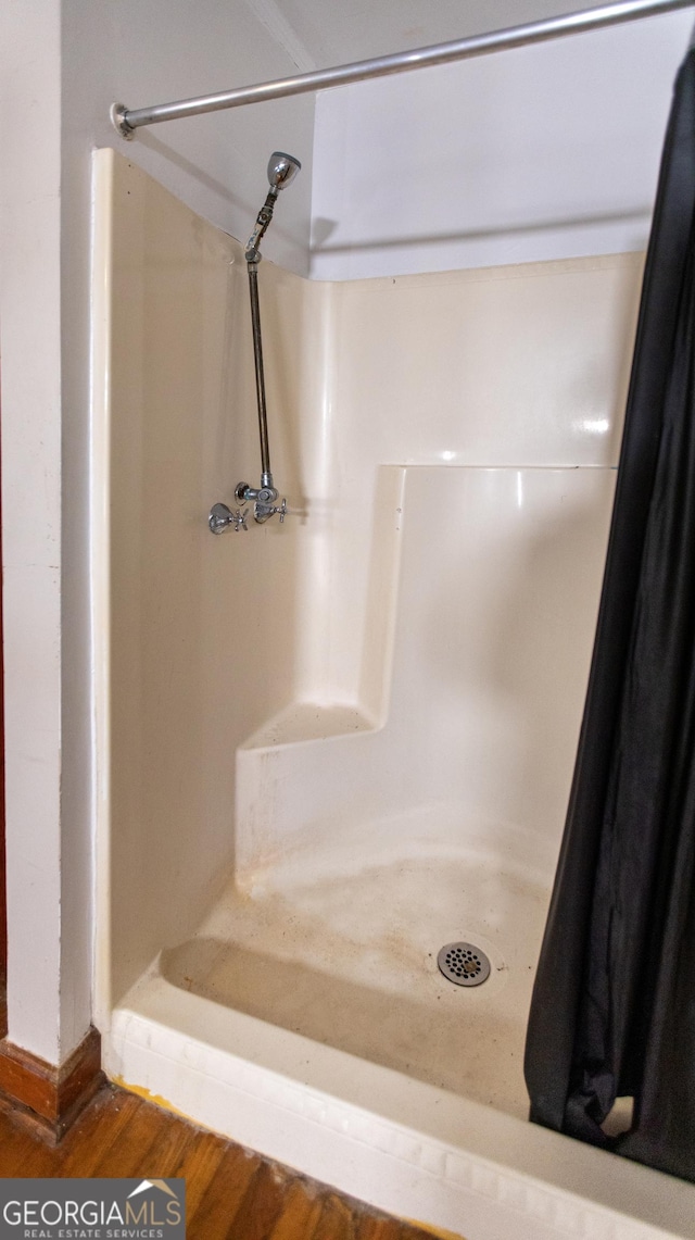 full bath with wood finished floors and a shower stall