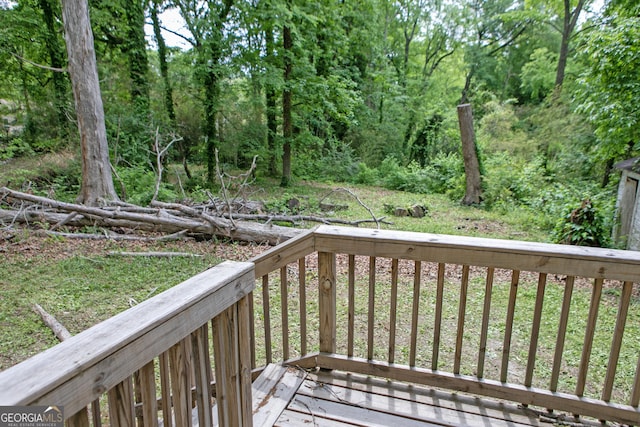 wooden terrace featuring a view of trees