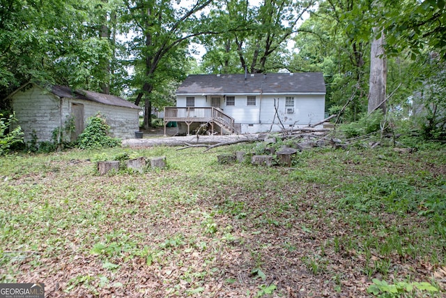 back of property featuring crawl space, an outbuilding, a wooden deck, a storage unit, and stairs