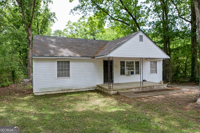 view of front of property with cooling unit, a porch, and a front lawn