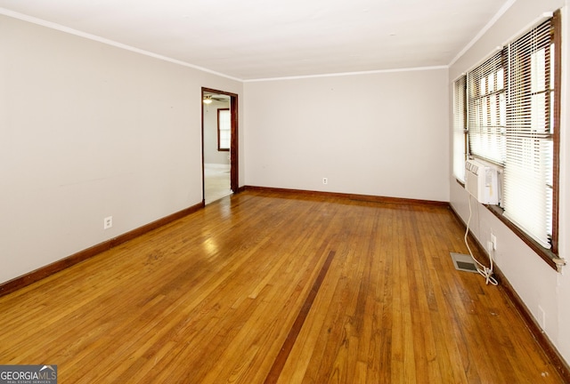 spare room with crown molding, baseboards, visible vents, and light wood-style floors